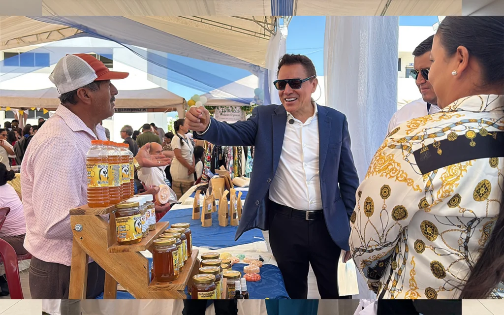 Presidente de CAPSE conversa con un productor de miel artesanal durante la Feria PYMES UPSE en Santa Elena