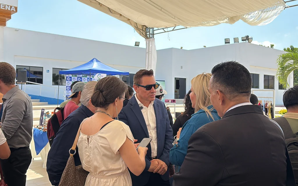 Emprendedores y asistentes dialogan con el presidente de CAPSE junto al stand de la Cámara en la UPSE